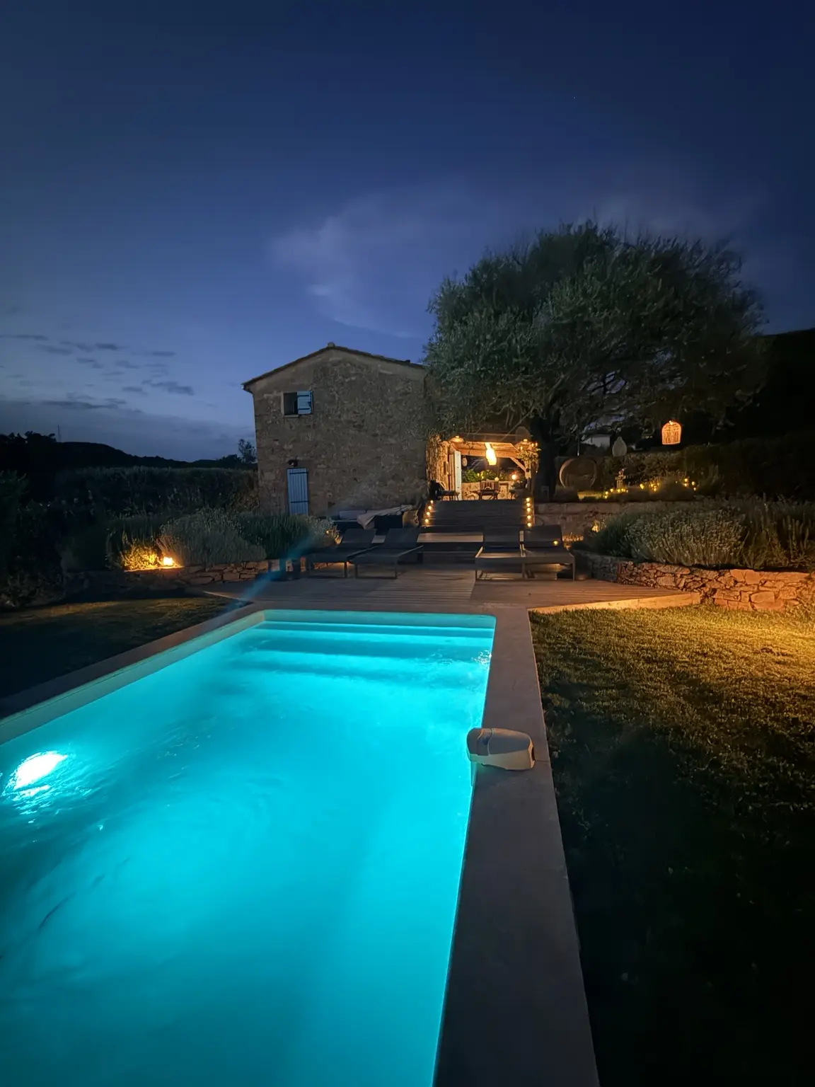 La piscine et la Bergerie illuminées à la tombée du jour